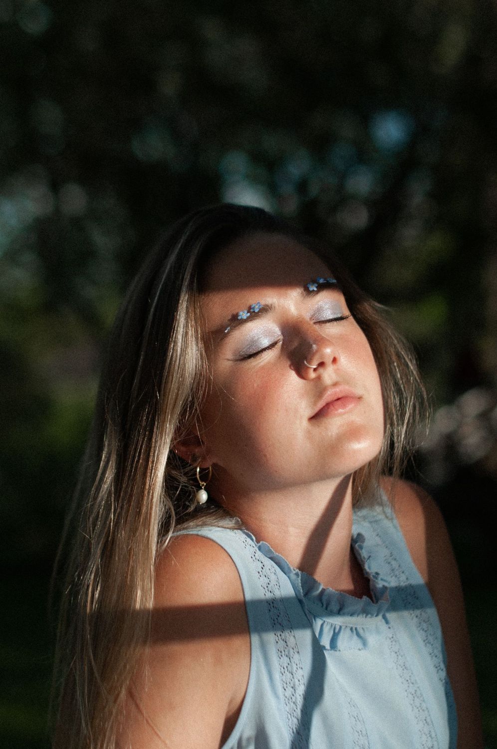 Frau mit geschlossenen Augen im Licht (Symbolbild)